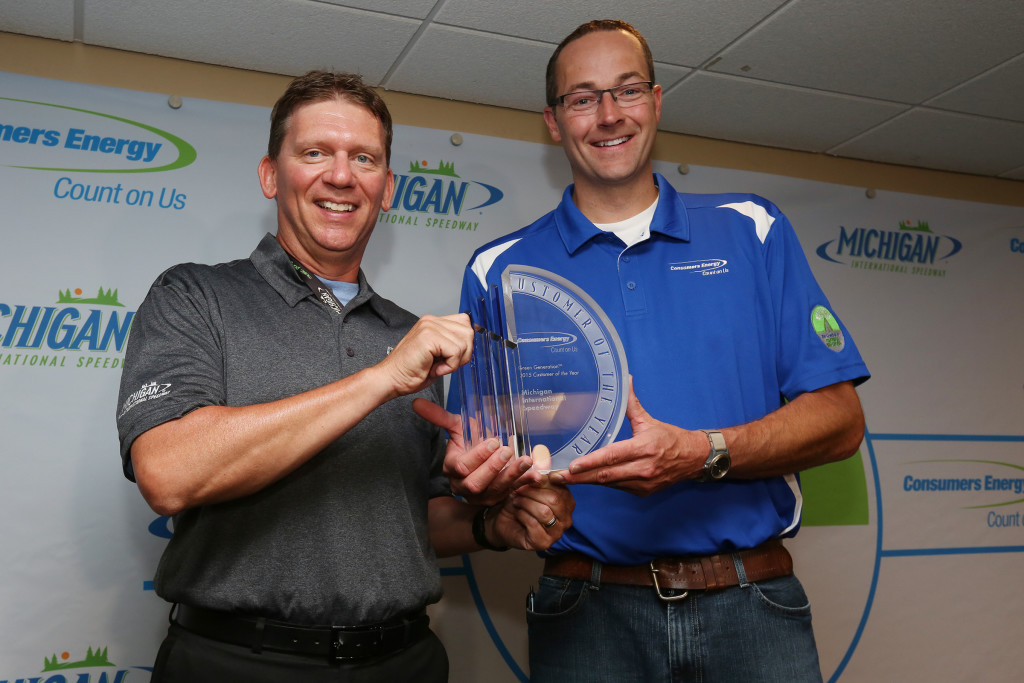 Michigan International Speedway President Roger Curtis accepts the Green Generation Customer of the Year award from Consumers Energy Vice President and Chief Customer Officer Garrick Rochow prior to the Pure Michigan 400. (credit: Michigan International Speedway)