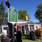 Image of people posting a historical marker in front of the home
