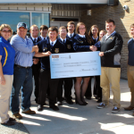 Students and instructors stand together presenting their grant.