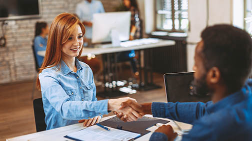 Young woman signing contracts and handshake with a manager